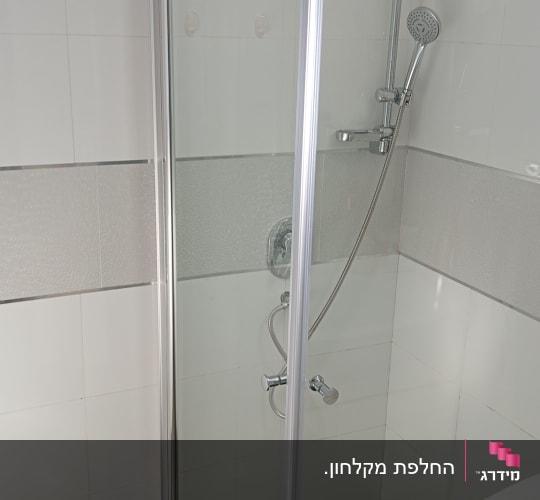 מקלחון פינתי מזכוכית שקופה המותקן בפינת חדר רחצה